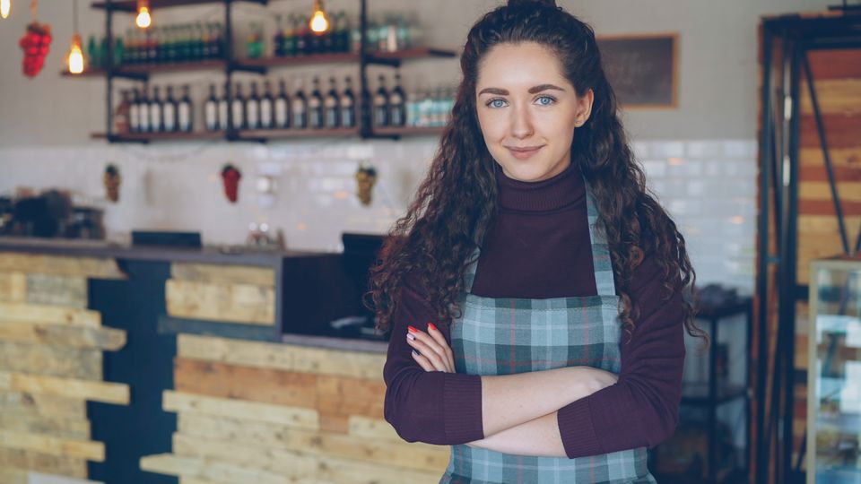 Cafe owner in a cozy coffee shop, used in an illustrative cafe website concept